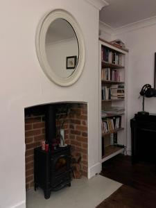 sala de estar con chimenea y espejo en Beautiful cottage near London, en Maidenhead