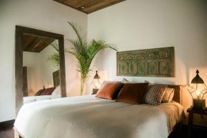 a bedroom with a large bed with a mirror at Soulshine Bali in Ubud