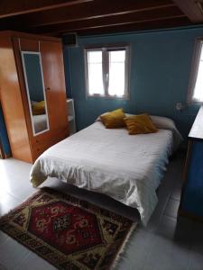 1 dormitorio con 1 cama grande en una habitación azul en La cabañina de zuce, en Parres de Llanes