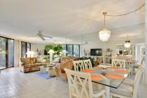 - une salle à manger et un salon avec une table et des chaises dans l'établissement Atlantic Paradise by AvantStay Great Location w Balcony Outdoor Dining Shared Pool Hot Tub, à Key West