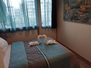 un animal de peluche tirado en una cama en un dormitorio en Magnifique Apt à deux pas du lac et près du centre, en Annecy