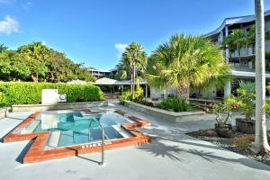 une piscine bordée de palmiers et un bâtiment dans l'établissement Atlantic Paradise by AvantStay Great Location w Balcony Outdoor Dining Shared Pool Hot Tub, à Key West
