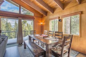 comedor con mesa de madera y sillas en Mahogany by AvantStay Snowbird Cabin w Full Chamberlands Access, en Homewood