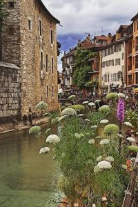 un río en una ciudad con edificios y flores en Magnifique Apt à deux pas du lac et près du centre, en Annecy