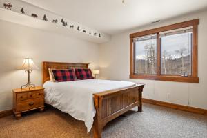 um quarto com uma cama e uma janela em Russell Home by AvantStay Expansive Deck Stunning Views Hot Tub em Telluride