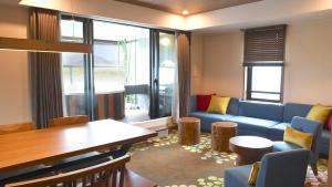 sala de estar con sofá azul y mesa en Karuizawakurabu Hotel 1130 Hewitt Resort, en Tsumagoi