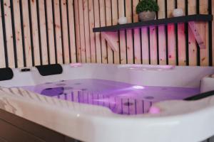 bañera púrpura en una habitación con pared en Apartments Sunrise Banovci, en Banovci