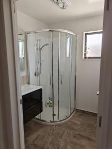 a bathroom with a glass shower with a sink at Hunter 3 Bedroom Apartment C in Lake Tekapo