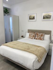 a bedroom with a large bed with white sheets at The Bridge house of Toledo in Toledo