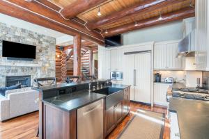 a kitchen with a counter top and a living room at Villas At Tristant 137 by AvantStay Ski In Ski Out Home w Panoramic Views Hot Tub in Telluride