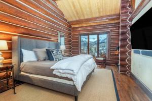 a bedroom with a bed and a wooden wall at Villas At Tristant 137 by AvantStay Ski In Ski Out Home w Panoramic Views Hot Tub in Telluride
