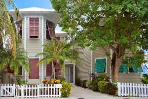 uma cerca branca em frente a uma casa com palmeiras em Amelia Home by AvantStay In Historic Old Town w Pool em Key West
