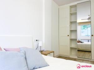 um quarto com uma cama branca e um espelho em La Promenade em Benicàssim