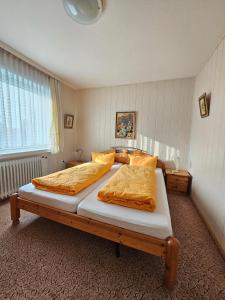 1 dormitorio con 2 camas y mantas de naranja en Ferienhaus Flechtner, en Norderney
