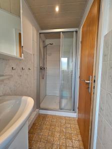 y baño con ducha, lavabo y bañera. en Ferienhaus Flechtner, en Norderney