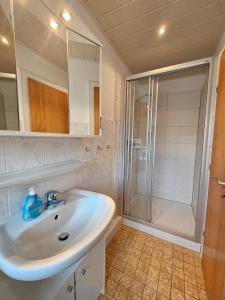 y baño con lavabo blanco y ducha. en Ferienhaus Flechtner, en Norderney
