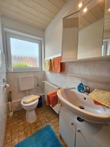 baño con lavabo y aseo y ventana en Ferienhaus Flechtner, en Norderney