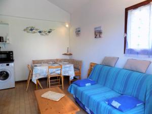 een woonkamer met een blauwe bank en een tafel bij La Palmyre - LUMINEUSE VILLA MITOYENNE - JARDIN - PISCINE COLLECTIVE in Les Mathes