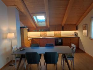 une salle à manger avec une table et des chaises ainsi qu'une cuisine dans l'établissement Ferienwohnungen Rohnbogner, à Point