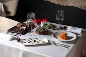 a table with plates of food and glasses of wine at Venus Hotel in Pristina