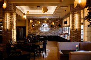 a restaurant with tables and chairs and a brick wall at Hotel Szyszko in Suwałki