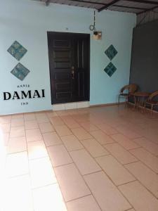 居鑾的住宿－NANIE DAMAI INN，一间设有白色墙壁和桌椅的房间