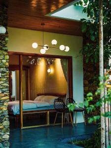 a bedroom with a bed and a mirror at Tổ Boutique Garden in La Gi