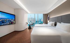 Voodi või voodid majutusasutuse Intercity Hotel Futian Bin He Zhongzhou Bay toas