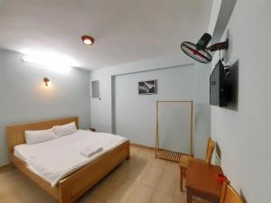 um quarto com uma cama e uma televisão em Capital O 1221 Thien An Hotel em Ho Chi Minh