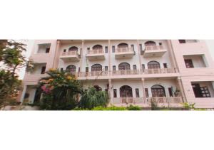 ein großes weißes Gebäude mit Balkonen darauf in der Unterkunft Hotel Fort View Madhya Pradesh in Tīkamgarh