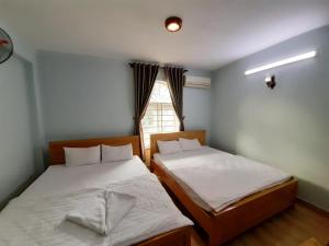 Duas camas num pequeno quarto com uma janela em Capital O 1221 Thien An Hotel em Ho Chi Minh