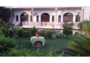 ein großes weißes Haus mit einem Tisch im Hof in der Unterkunft Hotel Fort View Madhya Pradesh in Tīkamgarh