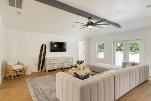 uma sala de estar com um sofá e uma ventoinha de tecto em Lumie by AvantStay 5BR Ranch w Firepit Patio em Isle of Palms