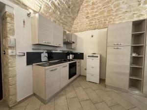 a kitchen with white appliances and a stone ceiling at NG Collection Piazza Castello in Sassari +4 photos