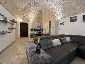 a living room with a couch and a bottle of wine at NG Collection Piazza Castello in Sassari