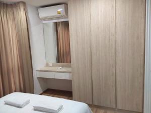 y baño con cama, lavabo y espejo. en Sukhumvit​ 101 en Phra Khanong