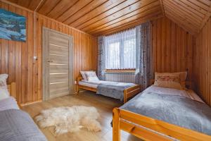 a bedroom with two beds and a dog laying on the floor at Apartament u Wróbla in Leśnica