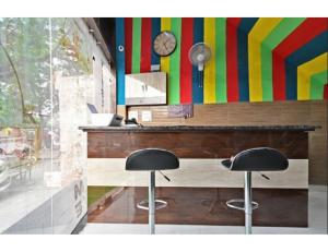 a bar with two stools in front of a colorful wall at Hotel Raj Inn, Agra in Agra