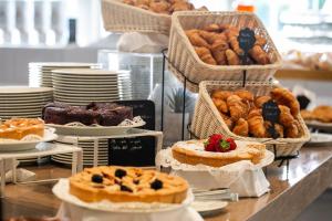 a buffet of pastries and breads on a table at Living Place Hotel in Villanova