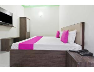 a bedroom with a large bed with pink pillows at Hotel Raj Inn, Agra in Agra