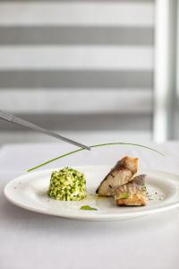 a white plate with food on a table with a fork at Living Place Hotel in Villanova