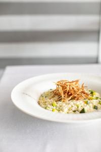 a white plate with a dish of food on a table at Living Place Hotel in Villanova