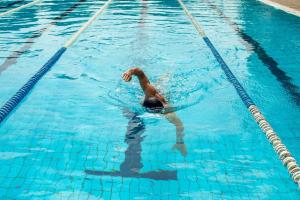 a man swimming in a swimming pool at Living Place Hotel in Villanova
