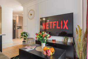 a living room with a netflix sign on a wall at Lumina I Premium Apartments with Balcony I Parking I Pasaż Łódzki in Łódź