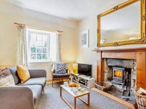 a living room with a fireplace and a mirror at 1 Bed in Aviemore 28823 in Nethy Bridge