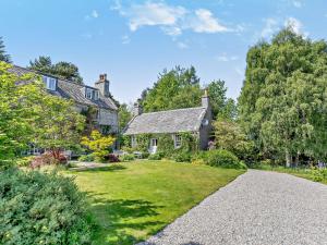 an old house with a garden and a driveway at 1 Bed in Aviemore 28823 in Nethy Bridge