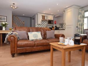 a living room with a brown couch and a table at 1 Bed in Durham HISHO in Lanchester