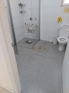 a bathroom with a toilet and a dirty floor at הירקון 10 in Tel Aviv