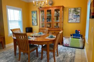 a dining room with a wooden table and chairs at Coral Garden by AvantStay Great Location w Balcony Shared Pool Month Long Stays Only in Stock Island