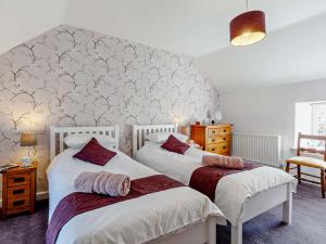 a bedroom with two beds and a wall at 3 Bed in Baslow PK917 in Baslow